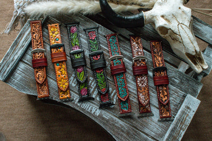 Collection of handcrafted tooled leather Apple Watch bands featuring boho sunflower, turquoise Celtic, oak leaf, red rose, tulip, and western floral designs