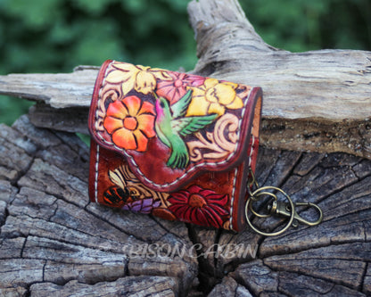Handcrafted wildflower leather AirPods cases featuring hummingbird artwork, embossed flowers, and antique-style metal hardware.