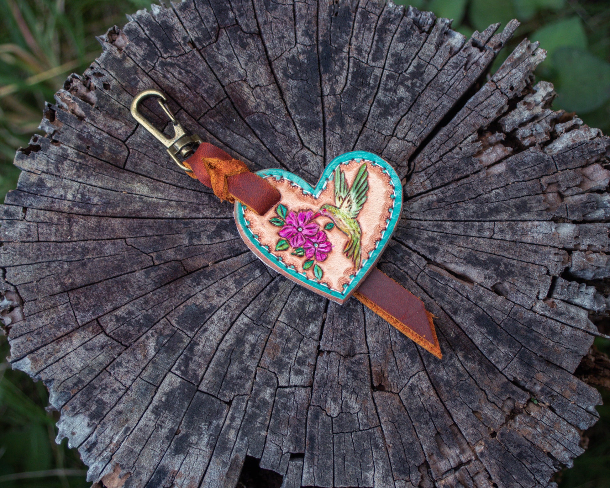 Handcrafted tooled leather heart charm featuring detailed hummingbird design, rustic Western style keychain with delicate leather carving and decorative charm accessory finish