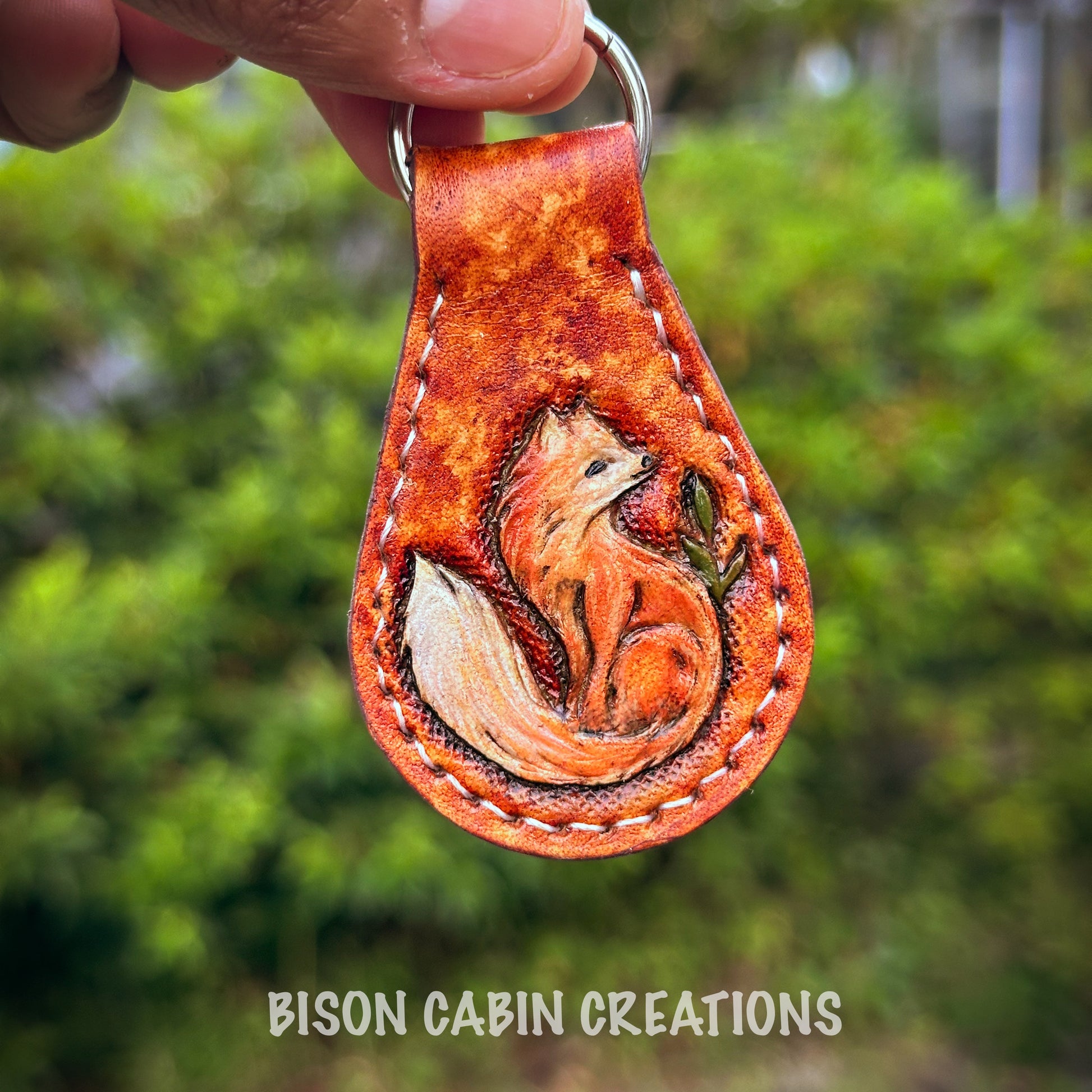 Hand-made, tooled leather keychain featuring red fox, rustic hand-painted details with medium brown leather, and nature-inspired key fob.