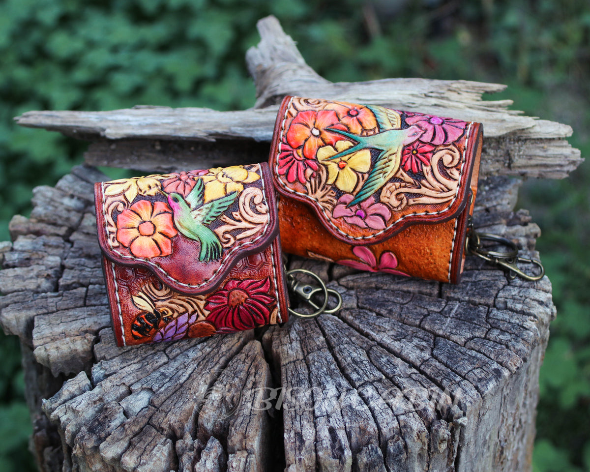Handcrafted tooled leather AirPods case featuring colorful flowers and a hummingbird and Songbirds design.