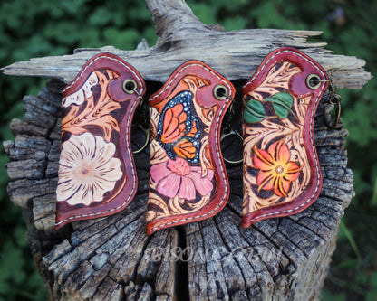 Hand-tooled floral leather lighter case with a white flower and Western scroll carving, handmade cowhide leather keychain holder.
