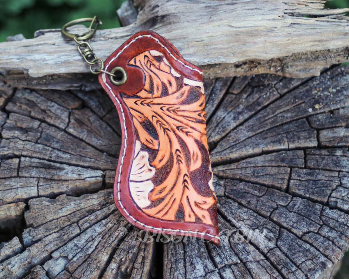 Handmade Western leather lighter holder with intricate wildflower carving, burgundy edges, hand-stitched detailing, and a convenient keychain attachment.
