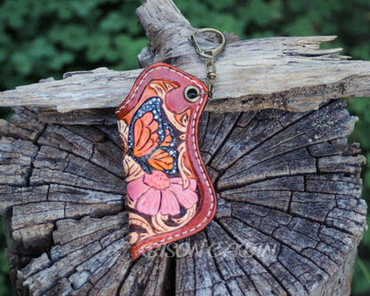 Handmade butterfly leather lighter case featuring a colorful orange and blue monarch butterfly, pink flower, and hand-tooled Western scroll design.