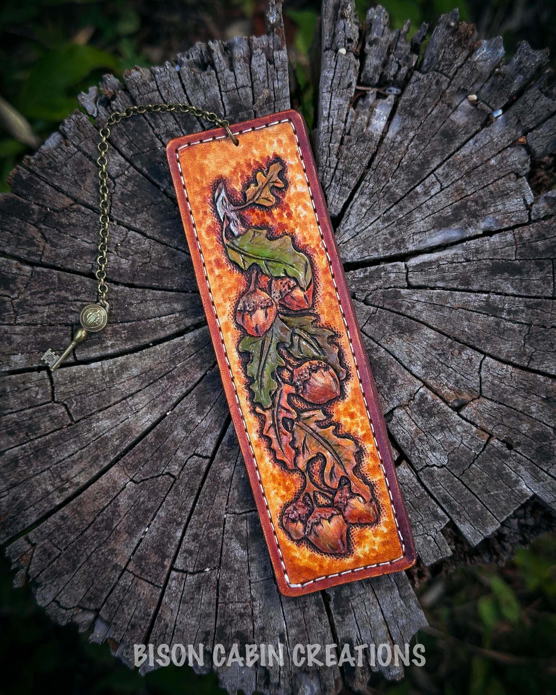 Handcrafted leather bookmark with nature-themed design featuring an Oak leaf, 'Bison Cabin Creations' branding.