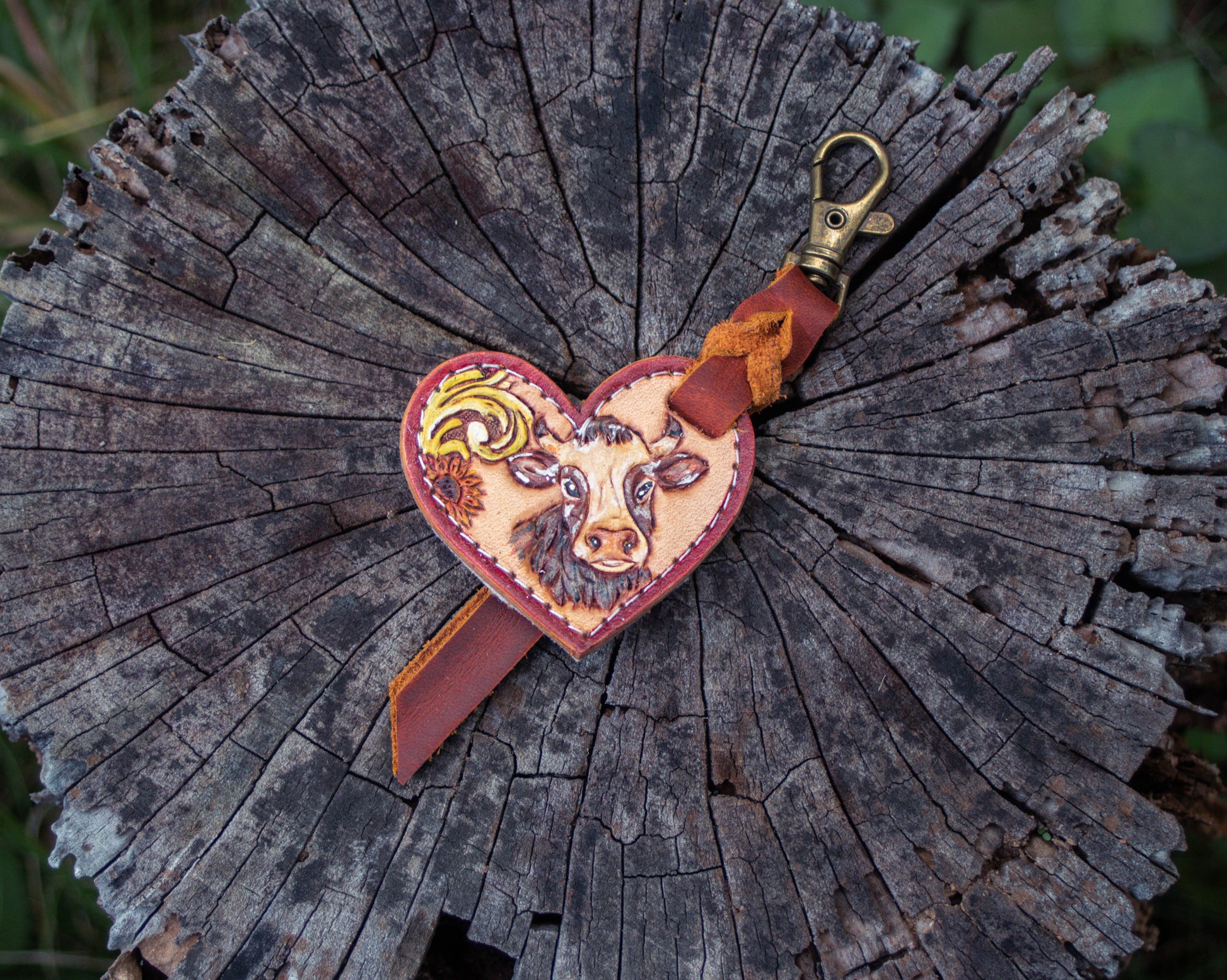 Handcrafted tooled leather heart charm featuring a detailed cow design, rustic Western style keychain with hand carved leather detailing and charm accessory finish